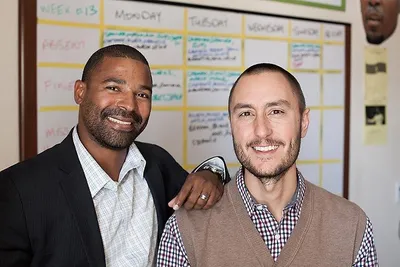 Zach McComsey and Tony Rosendo smiling in a classroom at Atlas Preparatory School